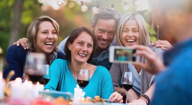 stock photography showing friends getting their photo taken at a dinner party