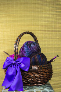 http://www.dreamstime.com/royalty-free-stock-images-basket-colorful-purple-pink-variegated-yarn-knitting-needles-visible-large-purple-bow-textured-straw-mat-as-background-space-text-image29724839