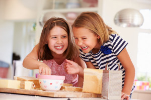 Girls Eating Ingredients Whilst Making Cheese On Toast