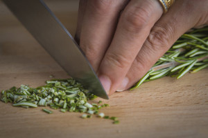 Chef chopping a rosemary branch