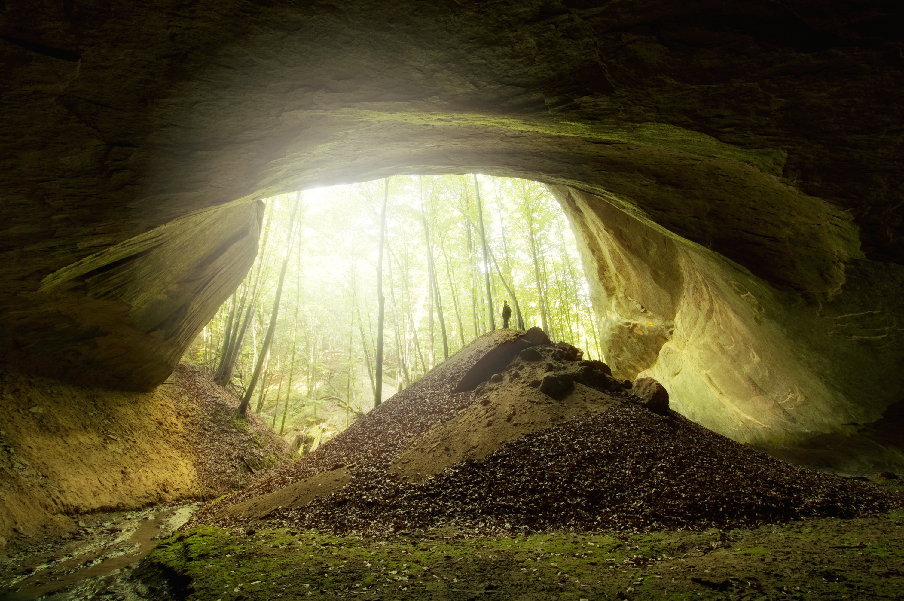 cave entrance with man and light