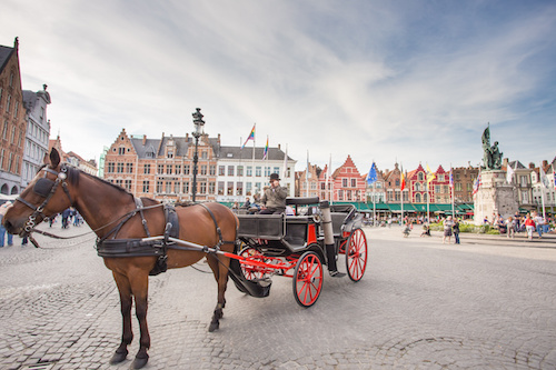 BRUGES, BELGIUM - MAY 17: The Carriage on the Grote Markt and Belfort van Brugge in background on 17 May 2014